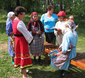 Maina jagab külarahvale udmurdikeelset kristlikku kirjandust.  Foto: EEA Evangelismi- ja misjonitoimkonna arhiiv